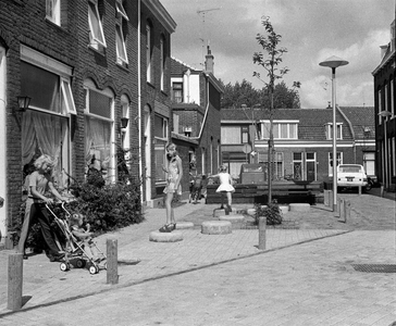 857238 Gezicht in de als leefstraat met plantenbakken en bankjes ingerichte Graanstraat te Utrecht, met enkele spelende ...